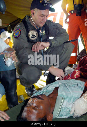 050103-N-9951E-162 Aceh, Sumatra, Indonesia (Jan. 3, 2005) - Lt. Mark Banks, of Savannah, Ga., tends to a patient flown-in by a U.S. Navy helicopter to a temporary triage site in Aceh, Sumatra. Medical teams from USS Abraham Lincoln (CVN 72), Carrier Air Wing Two (CVW-2) and the International Organization for Migration (IOM) set-up a triage site located on Sultan Iskandar Muda Air Force Base, in Banda Aceh, Sumatra. The two teams worked together with members of the Australian Air Force to provide initial medical care to victims of the Tsunami-stricken coastal regions. The Abraham Lincoln Carri Stock Photo