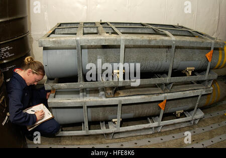 050119-N-5464G-036 Pacific Ocean (Jan. 19, 2005) - Airman Candice Bell, from West Forks, Maine, catalogs and inventories a palette of BLU-109, 2000-pound penetrator bombs as they enter one of USS Kitty Hawk (CV 63) magazines. Bell's inventory accounts for the amount, type, and location of all weapons stored aboard Kitty Hawk. Currently under way in the 7th Fleet area of responsibility (AOR), Kitty Hawk demonstrates power projection and sea control as the U.S. Navy's only permanently forward-deployed aircraft carrier, operating from Yokosuka, Japan. U.S. Navy photo by Photographer's Mate Airman Stock Photo