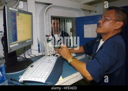 050301-N-9866B-002 Pacific Ocean (Mar. 1, 2005) - Disbursing Clerk 2nd Class Gene Tecson checks the balance of a customer’s Navy Cash Card account aboard the amphibious assault ship USS Peleliu (LHA 5). The system eliminates cash and coins from the entire ship and instead requires Sailors to add money from their personal bank accounts to one of two systems held on the cash card. U.S. Navy photo by Journalist 3rd Class Zack Baddorf (RELEASED) US Navy 050301-N-9866B-002 Disbursing Clerk 1st Class Gene Tecson checks the balance of a customer's Navy Cash Card account Stock Photo