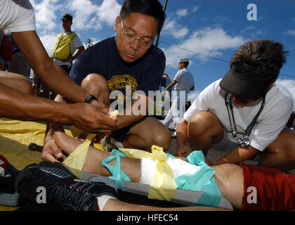 050415-N-3019M-009 Pearl Harbor, Hawaii (Apr. 15, 2005) - Sailors assigned to Naval Health Clinic, Makalapa treat and bandage Hospital Corpsman 3rd Class Sherwyne Santos during a mass casualty/decontamination drill on Pearl Harbor. The Federal Fire Department and Naval Health Clinic, Makalapa teamed up for the classroom and hands-on exercise to train as primary and secondary responders in the event of an emergency. U.S. Navy photo by Journalist 3rd Class Ryan C. McGinley (RELEASED) US Navy 050415-N-3019M-009 Sailors assigned to Naval Health Clinic, Makalapa treat and bandage Hospital Corpsman  Stock Photo