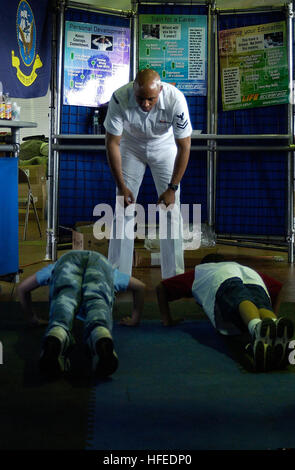 050530-N-5637H-003 New York, NY (May 30, 2005) Ð Naval Reservist, Master-at-Arms 2nd Class David Coleman, watch two young kids as they perform push-ups for posters at the Navy Recruiting District New York display during Fleet Week 2005 festivities in New York City. More than 100,000 people visited the display during the week-long event. U.S. Navy photo (RELEASED) US Navy 050530-N-5637H-003 Naval Reservist, Master-at-Arms 2nd Class David Coleman, instructs two young kids as they perform push-ups for posters at the Navy Recruiting District New York display Stock Photo