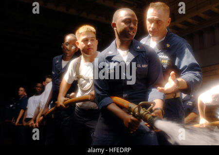 050531-N-4309A-394 Persian Gulf (May 31, 2005) Ð Disbursing Clerk 3rd Class James Njuguna receives instruction and training from Chief Hull Technician Damon Gilbert during a fire drill aboard the dock landing ship USS Ashland (LSD 48). This training is necessary to build confidence and experience for hose handlers in the event of an actual fire. Ashland is currently conducting Maritime Interception Operations  (MIO) in the Northern Persian Gulf. U.S. Navy photo by Photographer's Mate 1st Class Aaron Ansarov (RELEASED) US Navy 050531-N-4309A-394 Disbursing Clerk 3rd Class James Njuguna receives Stock Photo