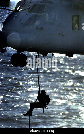 030117-N-3443B-001 At sea aboard USS Mount Whitney (LCC/JCC 20) Jan. 17, 2003 -- An unidentified U.S. Navy SEAL (SEa, Air, and Land) conducts a fast-rope insertion onto the deck of the amphibious command ship. The evolution was part of a simulated Maritime Interception Operation (MIO) training exercise.  U.S. Navy SEALs are deployed throughout the world conducting missions in support of Operation Enduring Freedom.  U.S. Navy photo by Chief Petty Officer Robert Benson.  (RELEASED) US Navy 030117-N-3443B-001 An unidentified U.S. Navy SEAL (SEa, Air, and Land) conducts a fast-rope insertion onto  Stock Photo