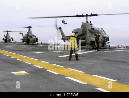 030113-N-9101V-001 At sea aboard USS Saipan (LHA 2) Jan. 13, 2003 -- AH-1W 'Cobra' helicopters from Marine Light Attack Helicopter Squadron Two Six Nine (HMLA-269) get directions prior to lift off from USS Saipan off the coast of North Carolina.  Saipan is part of an amphibious task force which will carry the North Carolina-based 2nd Marine Expedionary Brigade's 7,000 Marines on an undisclosed mission.  Marine aviation flying from Navy amphibious ships demonstrates the tight integration of the Navy-Marine Corps Team.  U.S. Navy photo by Photographer's Mate Airman Kyle Voight.  (RELEASED) US Na Stock Photo