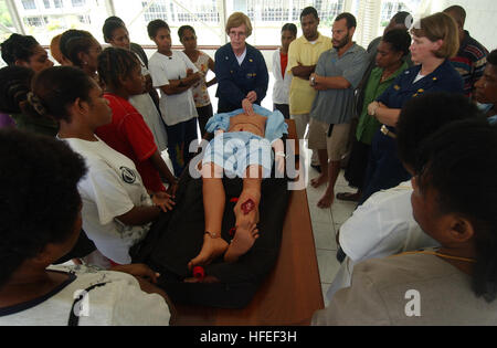 050516-N-7027P-118 Madang, Papua New Guinea (May 16, 2005) – Cmdr. Susanne Clark and Jeanie Comlish assigned to the Military Sealift Command (MSC) hospital ship USNS Mercy  (T-AH 19) demonstrate how to assess an injured patient upon arrival to the emergency room to the nursing students at the Lutheran School of Nursing in Madang, Papua New Guinea. Mercy and the MSC combat stores ship USNS Niagara Falls (T-AFS 3) are on station off the coast of Papua New Guinea to provide humanitarian assistance and focused medical care to the residents of the area. Mercy is en route to its homeport of San Dieg Stock Photo