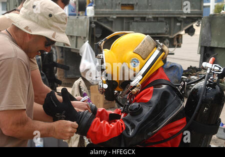 030311-N-5362A-012  Camp Patriot, Kuwait (Mar. 11, 2003) -- Chief Equipment Operator John Green assists Builder 2nd Class Jason Lane with his gloves before conducting a training dive at Camp Patriot. Chief Green and Petty Officer Lane are attached to Underwater Construction Team Two (UCT-2), which is forward deployed in support of Operation Enduring Freedom.  U.S. Navy photo by Photographer's Mate 1st Class Arlo K. Abrahamson.  (RELEASED) US Navy 030311-N-5362A-012 Chief Equipment Operator John Green assists Builder 2nd Class Jason Lane Stock Photo