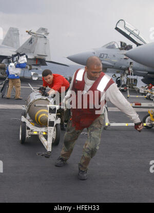 030321-N-0382O-504 The Mediterranean Sea (Mar. 21, 2003) -- Aviation Ordnancemen assigned to 'The Swordsmen' of Fighter Squadron Thirty Two (VF-32) transfer 2,000-lb. Joint Directional Attack Munition (JDAMs) for uploading to an F-14B Tomcat fighter aircraft.  JDAMs are guidance kits that convert existing unguided bombs into precision-guided 'smart' munitions. The tail section contains an inertial navigational system (INS) and a global positioning system (GPS). A JDAM improves the accuracy of unguided bombs in any weather condition.  Truman is currently deployed and is conducting missions in s Stock Photo