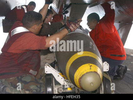 030321-N-0382O-506 The Mediterranean Sea (Mar. 21, 2003) -- Aviation Ordnancemen assigned to 'The Swordsmen' of Fighter Squadron Thirty Two (VF-32) upload a 2,000-lb. Joint Directional Attack Munition (JDAM) before it is loaded onto a F-14B Tomcat.  JDAM's are guidance kits that convert existing unguided bombs into precision-guided 'smart' munitions. The tail section contains an inertial navigational system (INS) and a global positioning system (GPS). A JDAM improves the accuracy of unguided bombs in any weather condition.  Truman is currently deployed and is conducting missions in support of  Stock Photo