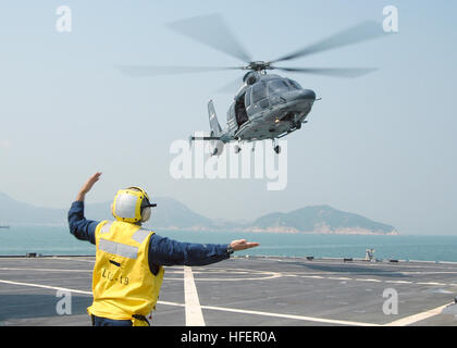 031101-N-8955H-002 Hong Kong (Nov. 1, 2003) -- Landing Signalman Enlisted (LSE) BoatswainÕs Mate 1st Class Joseph Mullen, from Seattle, Wash., signals an EC-155 Dauphin helicopter from the Hong Kong Government Flying Service to depart the ship's flight deck.  U.S. Navy photo by PhotographerÕs Mate 1st Class Novia E. Harrington.  (RELEASED) US Navy 031101-N-8955H-002 Landing Signalman Enlisted (LSE) Boatswain%%5Ersquo,s Mate 1st Class Joseph Mullen, from Seattle, Wash., signals an EC-155 Dauphin helicopter from the Hong Kong Government Flying Service to depart the sh Stock Photo