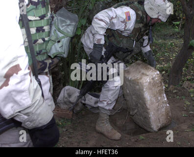 031217-A-0000X-001 Ad Dawr, Iraq (Dec. 17, 2003) -- A member of the 1st Brigade Combat Team lifts a Styrofoam lid covering the hole where former Iraqi dictator Saddam Hussein was discovered hiding at the time of his capture, in the village of Ad Dawr, which approximately 15 kilometers south of Tikrit, Iraq.  U.S Army photo by Staff Sgt. David Bennett.  (RELEASED) US Navy 031217-A-0000X-001 A member of the 1st Brigade Combat Team lifts a Styrofoam lid covering the hole where former Iraqi dictator Saddam Hussein was discovered hiding at the time of his capture Stock Photo