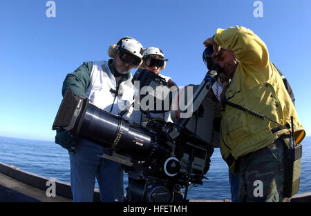 040129-N-0905-021 Pacific Ocean (Jan. 29, 2004) – Members of Columbia Pictures visual effects unit offer Aviation Boatswain’s Mate Alberto Melendez a look into the viewfinder of their video camera.  The film crew is aboard USS Carl Vinson (CVN 70) filming scenes for the upcoming motion picture 'Stealth.”  The Bremerton, Washington based nuclear powered aircraft carrier is currently underway for the first time since returning from an eight and half month western pacific deployment.  Carl Vinson is conducting training with Carrier Air Wing Nine (CVW-9) and units of the Carl Vinson Carrier Strike Stock Photo