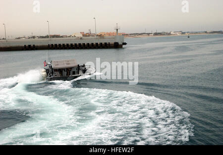 040222-N-0401E-013 Kuwait Naval Base, Kuwait (Feb. 22, 2004) Ð A patrol craft assigned to Coast Guard Port Security Unit Three Zero Seven (PSU 307) leaves the harbor to monitor activities around Kuwait Naval Base. Supplies are being ferried ashore via Landing Craft Air Cushion (LCAC) deployed from the amphibious assault ships USS Boxer (LHD 4), and USS Bataan (LHD 5), during on-going troop rotations supporting Operation Iraqi Freedom. PSU 307 works together with Navy Mobile Inshore Undersea Warfare Unit Two Zero Six (MIUW 206) to provide harbor security. U.S. Navy photo by Journalist 2nd Class Stock Photo