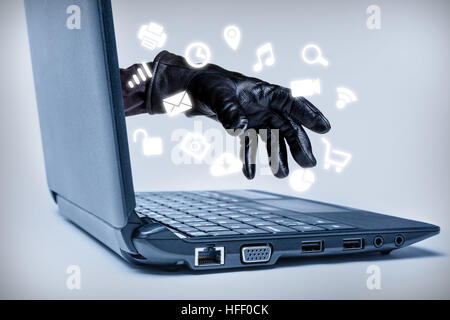 A gloved hand reaching out through a laptop with common media icons flowing, signifying a cybercrime or Internet theft while using various Internet me Stock Photo