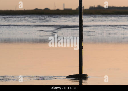 The base of a post at low tide at Leigh on Sea on a calm winter's day Stock Photo