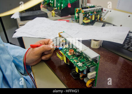Electronic engineer measures the electronic circuits on a circuitboard Stock Photo