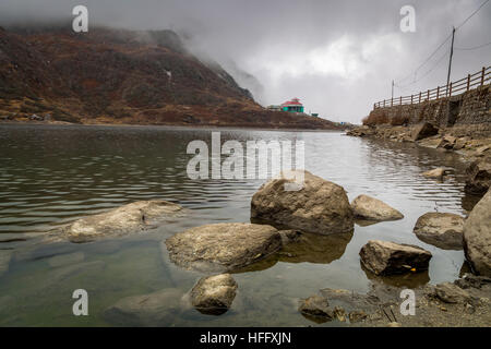 Lake Tsomgo (Changu) surrounded by barren mountains in East Sikkim, India on a foggy winter morning. Stock Photo