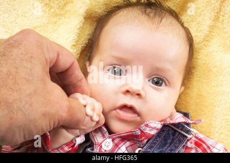 Baby holding its grandfather's thumb Stock Photo