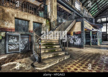 Imposing staircase inside the hall of an abandoned power plant Stock Photo