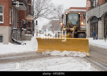 Montreal, CA - 12 December 2016: A snowplow in motion in Mile End Neighborhood during snow storm. Stock Photo