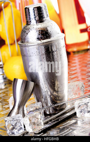Cocktail shaker, ice cubes, tongs and a measuring cup Stock Photo