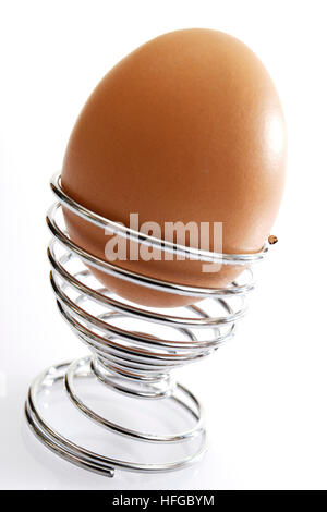 Brown egg in spiral eggcup Stock Photo