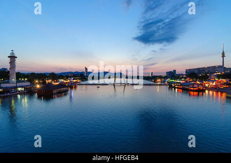 Wien, Vienna: restaurant mile Sunken City and Copa Cagrana on the New Danube, in front of the Millennium Tower, Donauturm and Donaucity at sunset behi Stock Photo
