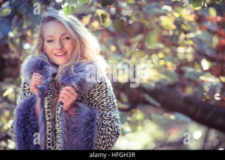 Photographic modeling as a career in the UK: A young slim attractive 20 year old caucasian woman girl with long blonde hair  alone by herself in woodlands on a warm bright autumn afternoon Stock Photo