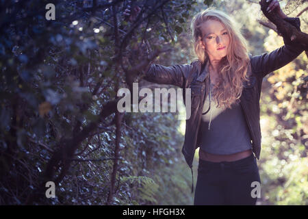 Photographic modeling as a career in the UK: A young slim attractive 20 year old caucasian woman girl with long blonde hair alone by herself in woodlands on a warm bright autumn afternoon Stock Photo