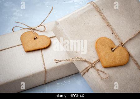 Gift boxes are packed in kraft paper with cookies - heart on Valentine's Day. Stock Photo