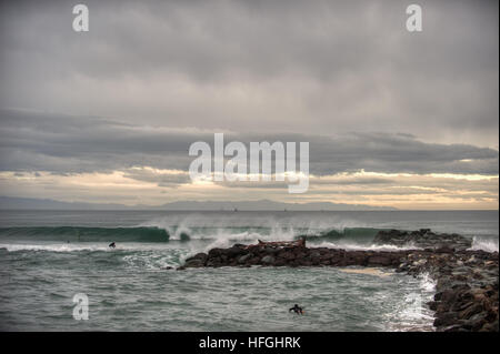 Morning clouds of rain texturing sky over Ventura Marina park surfers. Stock Photo