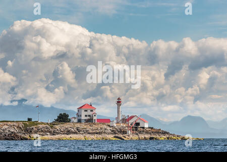 A close, water level view of Entrance Island Lighthouse off Gabriola Island, with blue sky and cumulus clouds towering over Howe Sound in the distance Stock Photo