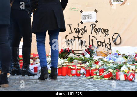 Berlin, Germany. 31st Dec, 2016. Grave candles flowers to commemorate the victims of the terrorist attack on 19 December 2016 have been placed at the Christmas market near the Memorial Church in Berlin, Germany, 31 December 2016. 'I wish peace for the world' can be read on the wall. Photo: Jens Kalaene/dpa-Zentralbild/dpa/Alamy Live News Stock Photo