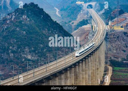 (170101) -- BEIJING, Jan. 1, 2017 (Xinhua) -- The G4136 train runs on the Shuitongmuzhai bridge of the Shanghai-Kunming high-speed railway in Anshun, southwest China's Guizhou Province, Dec. 28, 2016. China on Wednesday put into operation one of the world's longest high-speed railways, linking the country's prosperous eastern coast to the less-developed southwest. The Shanghai-Kunming line -- 2,252 km in length -- traverses the five provinces of Zhejiang, Jiangxi, Hunan, Guizhou and Yunnan and cuts travel time from Shanghai to Kunming from 34 to 11 hours, according to China Railway Corporation Stock Photo