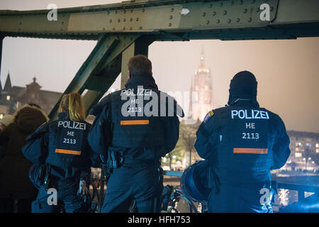 Police officers secure the Eiserner Steg footbridge in Frankfurt am Main, Germany, 31 December 2016. This year a large force of police officers secured the event. An additional separated security area was also erected that could accommodate 30,000 people following a security check upon entry. Photo: Boris Roessler/dpa Stock Photo