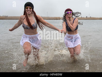 Hohenkirchen, Germany. 01st Jan, 2017. Lena (L) and Marieke are among the over fifty New Year's swimmers taking the opportunity to begin the new year with a swim in the lake in the Wangerland recreational area in Hohenkirchen, Germany, 01 January 2017. With air and water temperatures around four degrees celsius, swimming time was kept short. Photo: Ingo Wagner/dpa/Alamy Live News Stock Photo