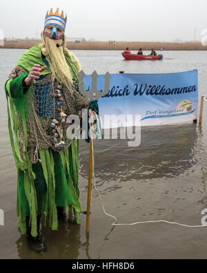 Hohenkirchen, Germany. 01st Jan, 2017. 'Neptune God of the Sea' announces the current water temperature during the traditional New Year's swim in the lake in the Wangerland recreational area in Hohenkirchen, Germany, 01 January 2017. Over fifty participants took a swim to welcome the new year. With air and water temperatures around four degrees celsius, swimming time was kept short. Photo: Ingo Wagner/dpa/Alamy Live News Stock Photo