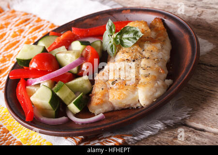 grilling fish fillets and fresh vegetable salad close-up on a plate. Horizontal Stock Photo