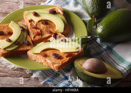 Sandwiches with peanut butter and ripe avocado close-up on a plate. horizontal Stock Photo