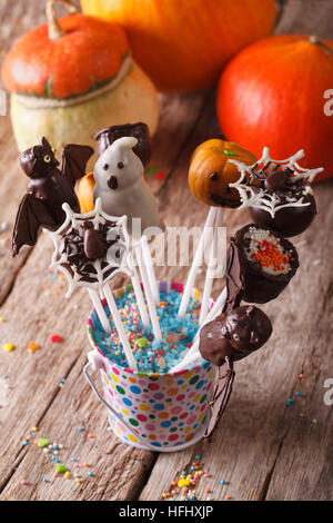Halloween cake pop in a bucket on the table and pumpkins. vertical Stock Photo
