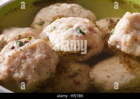 Delicious canederli in a broth close-up on a plate. horizontal Stock Photo