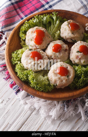 Delicious canederli with tomato sauce on a wooden plate closeup. Vertical Stock Photo