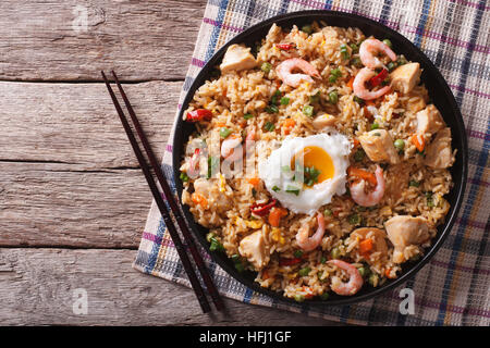 Asian fried rice nasi goreng with chicken, prawns, egg and vegetables horizontal view from above Stock Photo