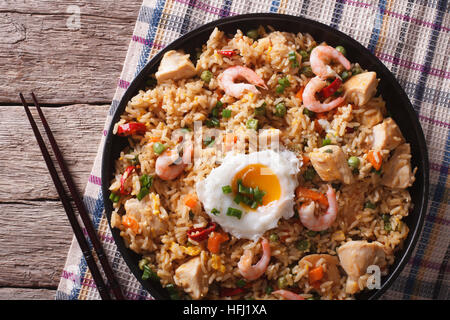 Asian fried rice nasi goreng with chicken, prawns, egg and vegetables close-up horizontal view from above Stock Photo
