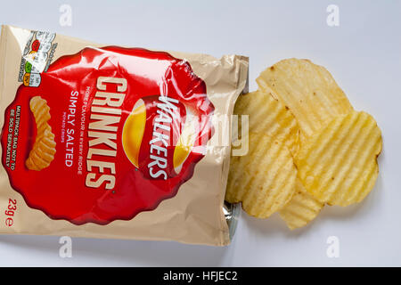 Packet of Walkers Crinkles simply salted potato crisps, more flavour in every ridge  opened to show contents on white background Stock Photo