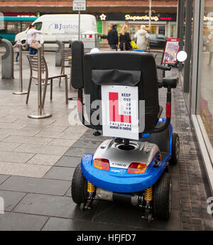 'L Plates' Dangerous woman driver Warning Sign on Mobility Scooter, handicapped transport, battery powered, wheelchair user, retirement vehicle in Chapel Street, Southport, Merseyside, UK Stock Photo