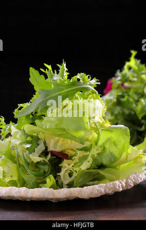 Fresh green salad mix on black background and space for text Stock Photo
