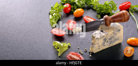 Blue cheese with tomato on stone background and space for text Stock Photo