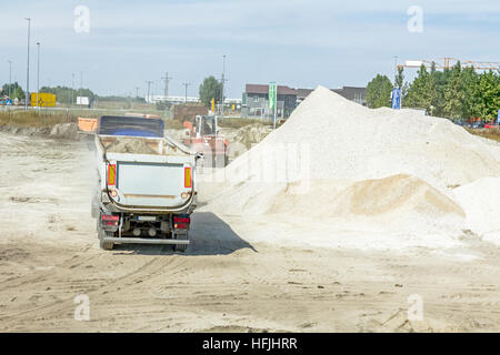 Big hydraulic dump truck is moving into reverse, prepare to unload cargo. Stock Photo