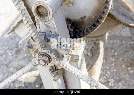Close up view on detail of cement mixer toothed mechanism machine at construction site. Stock Photo