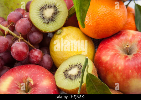 iron fruit basket with different fruits like apples, bananas, pears, grapes, kiwi Stock Photo